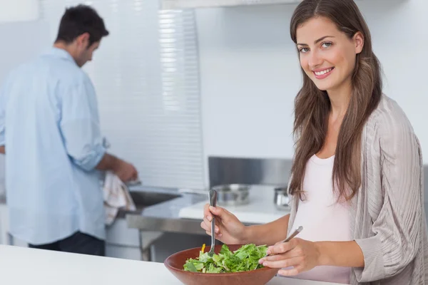 Donna che mescola un'insalata in cucina — Foto Stock