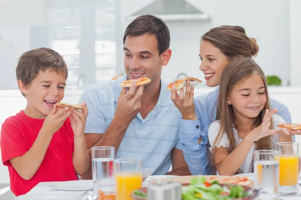 Happy family eating pizza slices — Stock Photo, Image