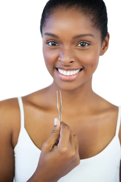 Mujer sonriente sosteniendo sus pinzas — Foto de Stock