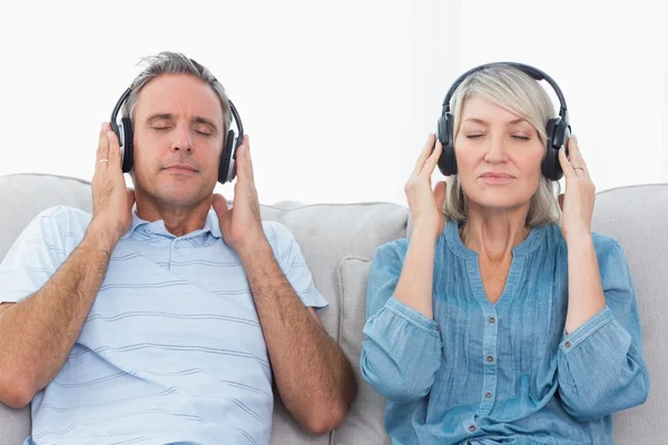 Pareja escuchando música en el sofá — Foto de Stock