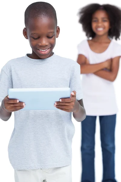 Мальчик смотрит на планшетный компьютер со своей сестрой — стоковое фото