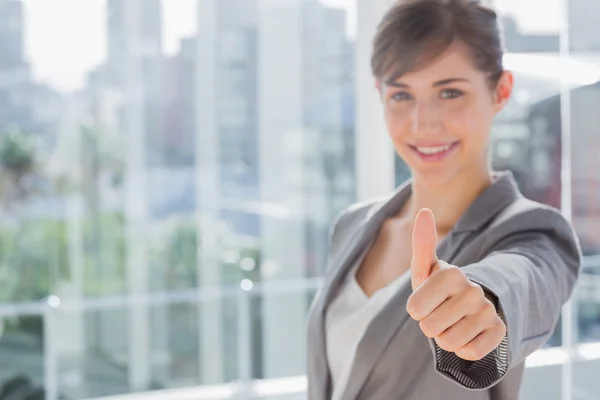 Smiling businesswoman giving thumb up at camera Stock Picture