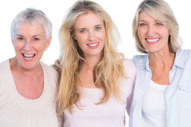 Three generations of cheerful women smiling at camera clipart