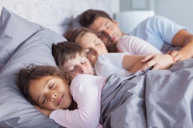 Cute family sleeping in bed clipart