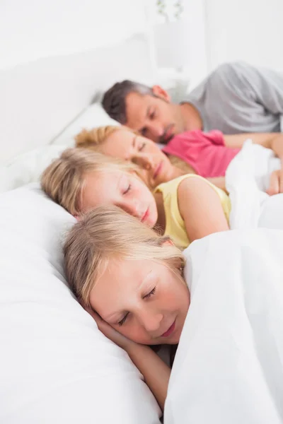 Parents sleeping with their twins in bed — Stock Photo, Image