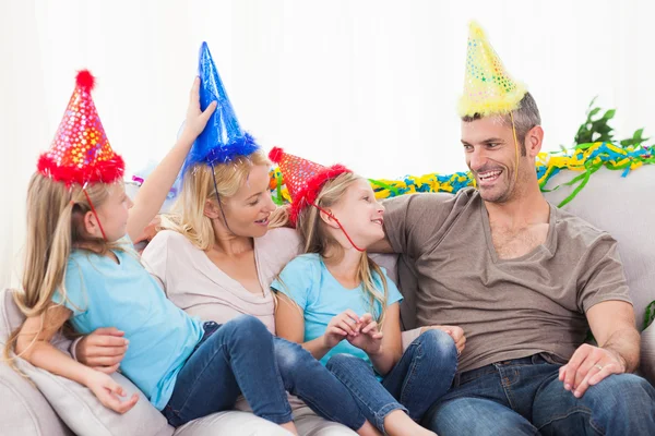 Famille célébrant l'anniversaire des jumeaux assis sur un canapé — Photo