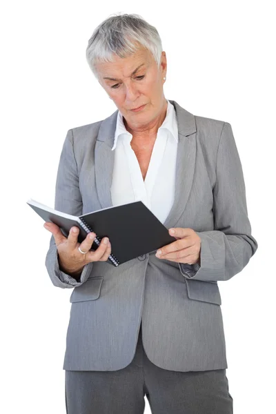 Empresária concentrada a ler bloco de notas — Fotografia de Stock