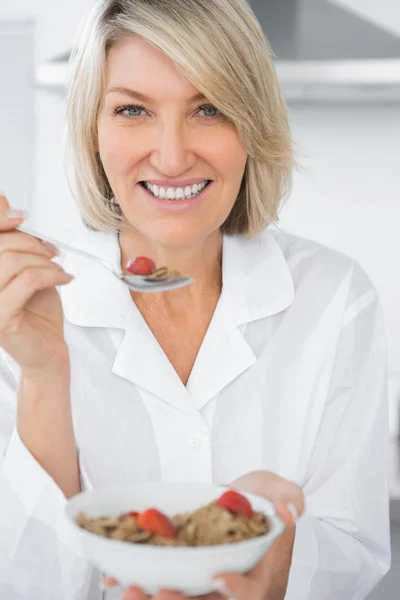 Glad kvinna äter flingor till frukost — Stockfoto