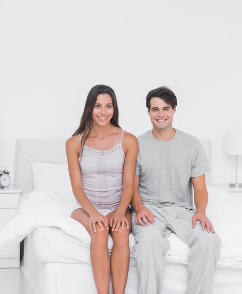 Cheerful couple sitting in bed — Stock Photo, Image