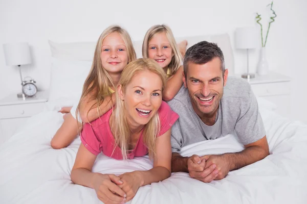 Retrato de los padres acostados en la cama con sus gemelos —  Fotos de Stock