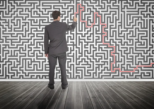 Empresário traçando uma linha vermelha em um labirinto — Fotografia de Stock