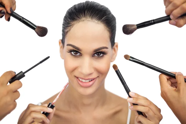 Schöne Frau von Make-up-Pinseln umgeben — Stockfoto