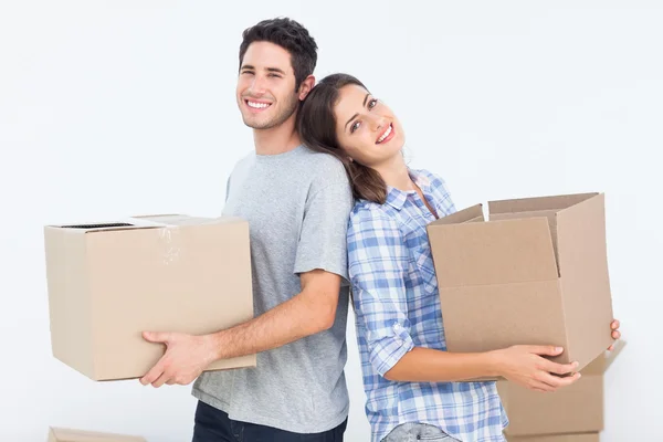 Wife and husband carrying boxes in their new house — Stock Photo, Image