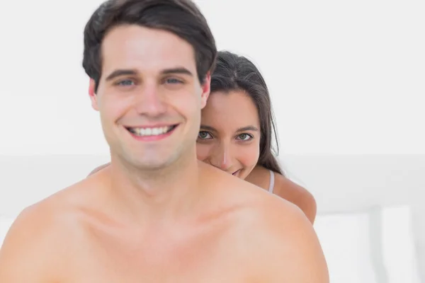 Woman hiding behind shirtless partner — Stock Photo, Image