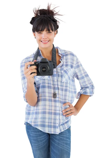 Smiling young woman with hand on her hip taking picture — Stock Photo, Image