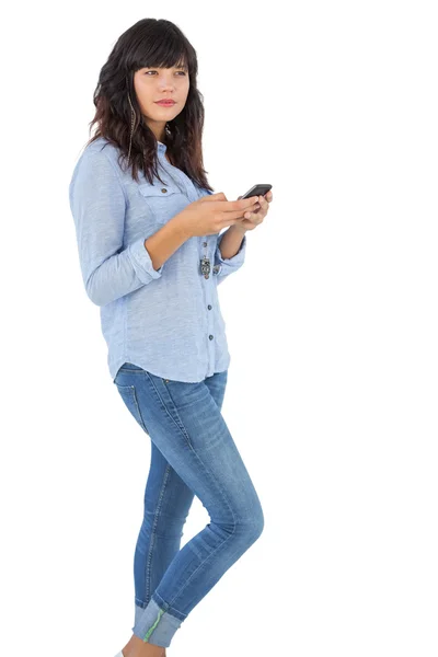 Tänkande brunett med hennes mobiltelefon textilen ett meddelande — Stockfoto