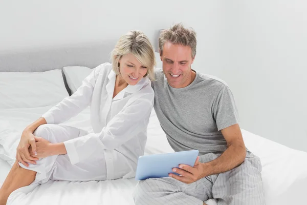 Casal feliz usando seu tablet digital — Fotografia de Stock