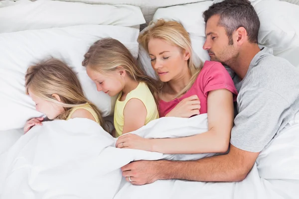 Батьки сплять у ліжку зі своїми близнюками — стокове фото