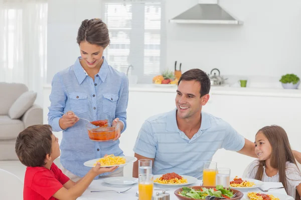 Femme donnant de la sauce pour pâtes à son fils — Photo