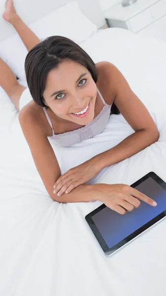 女人在床上使用她的平板电脑 — 图库照片
