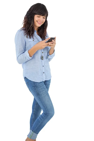 Morena sorridente com seu telefone celular enviando uma mensagem — Fotografia de Stock