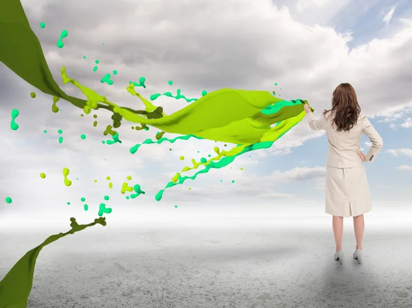 Creative businesswoman with green paint splash — Stock Photo, Image