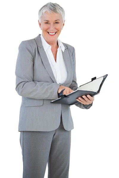 Mujer de negocios sonriente sosteniendo su diario — Foto de Stock