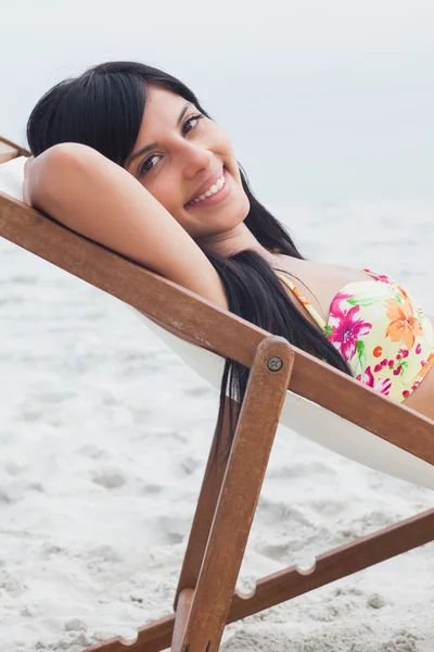 Mulher bonita que descansa na cadeira da plataforma — Fotografia de Stock