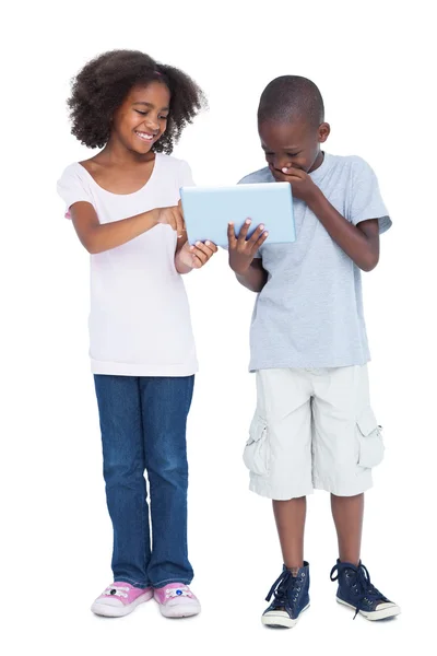 Grinende dreng kigger på tablet pc - Stock-foto