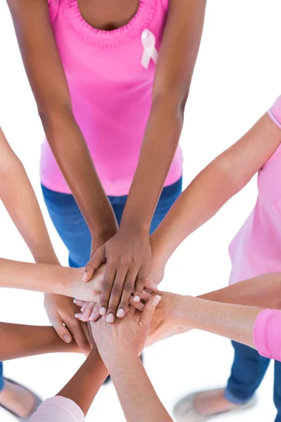 Grupo vistiendo de rosa y cintas para el cáncer de mama poniendo las manos t —  Fotos de Stock