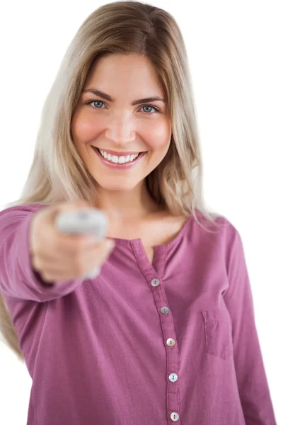 Smiling young woman changing channel — Stock Photo, Image