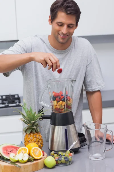 Man sätter en jordgubbe i mixern — Stockfoto