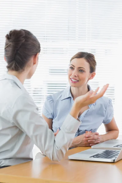 Mulheres de negócios conversando em sua mesa — Fotografia de Stock