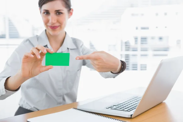 Młoda kobieta wskazuje Zielona wizytówka — Zdjęcie stockowe