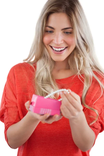 Blond kvinna upptäcker halsband i en presentförpackning — Stockfoto