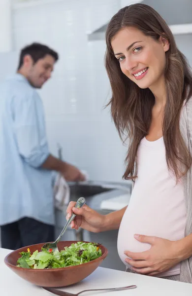 Femme enceinte préparant une salade dans la cuisine — Photo