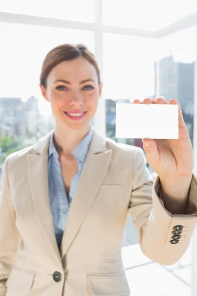 Lächelnde Geschäftsfrau hält leere Visitenkarte hoch — Stockfoto