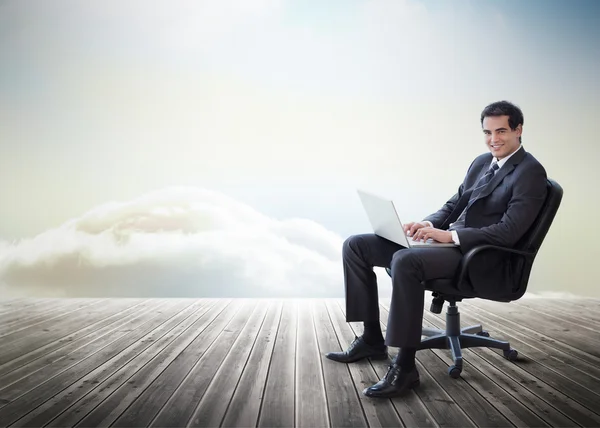 Hombre de negocios guapo sentado en una silla giratoria y usando su regazo —  Fotos de Stock