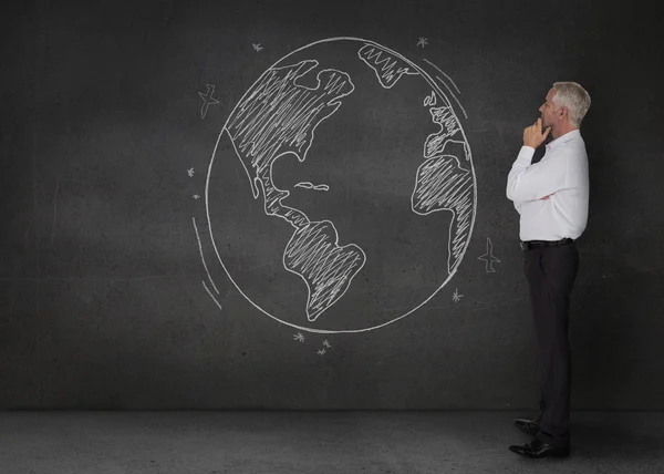 Doordachte zakenman kijken naar een aarde getekend met een krijt — Stockfoto