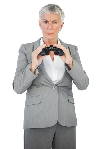 Unhappy businesswoman holding binoculars — Stock Photo, Image