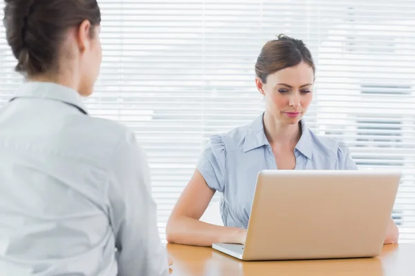 Femme d'affaires regardant ordinateur portable lors d'une interview — Photo