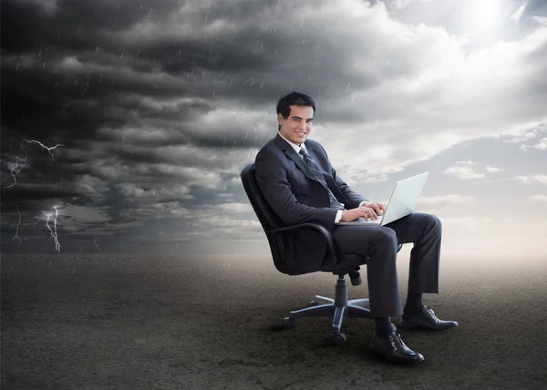 Attractive businessman using his laptop outside during stormy we — Stock Photo, Image