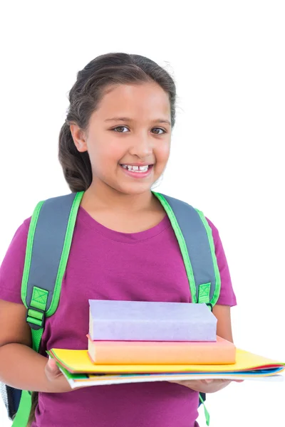 Χαμογελώντας μικρό κορίτσι φορώντας τσάντα το βιβλίο και κρατά την εργασία — Φωτογραφία Αρχείου