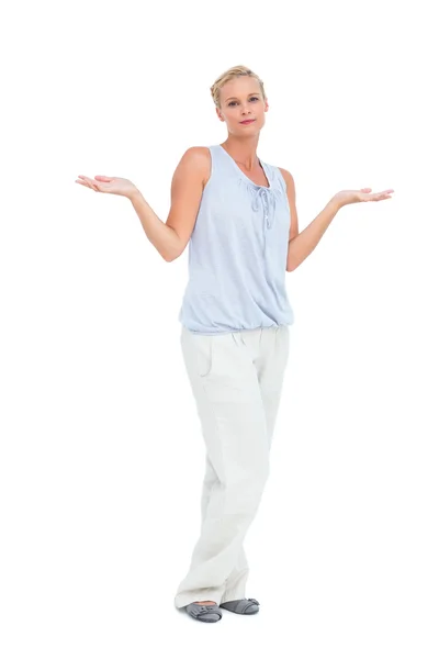 Blonde woman with arms raised in question looking at camera — Stock Photo, Image