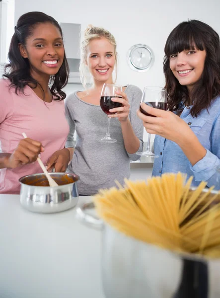 Счастливые друзья готовят спагетти вместе и пьют красное — стоковое фото
