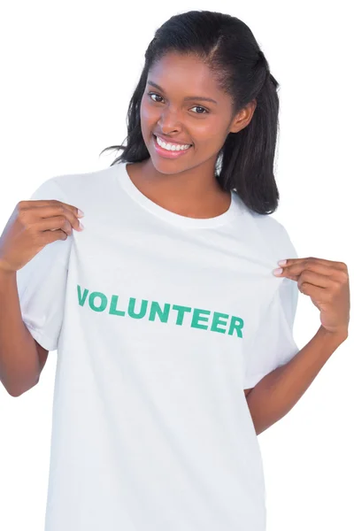 Young woman wearing volunteer tshirt and pointing to it — Stock Photo, Image