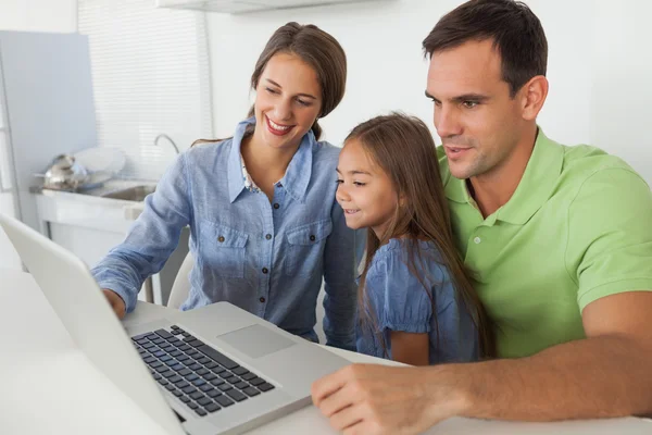 Familia usando un ordenador portátil PC en la cocina — Foto de Stock