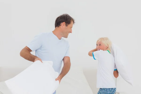 Padre e hijo teniendo una pelea de almohadas — Foto de Stock
