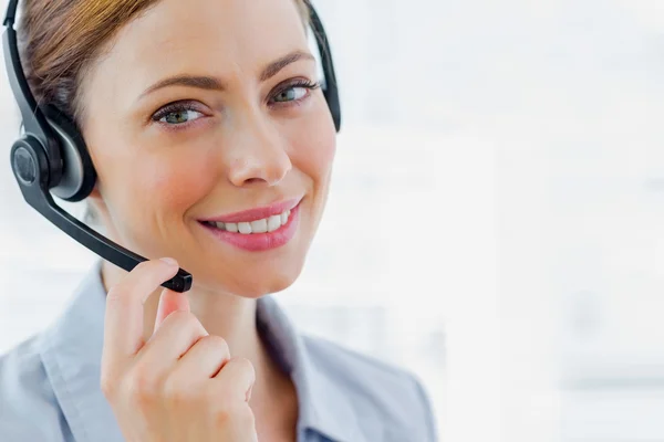 Call centre operator wearing headset smiling at camera — Stock Photo, Image