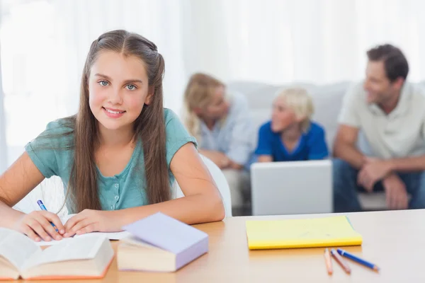 Usměvavá holčička dělá její domácí úkoly — Stock fotografie
